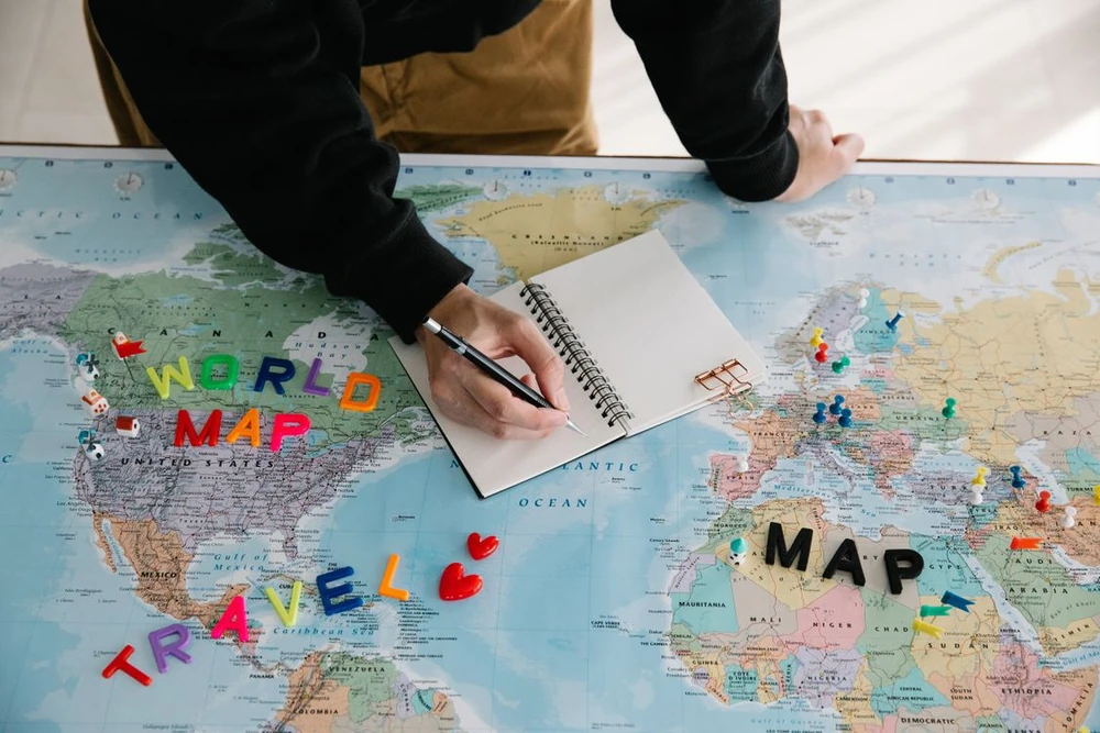 Una persona prepara notas sobre un mapa para planificar un viaje
