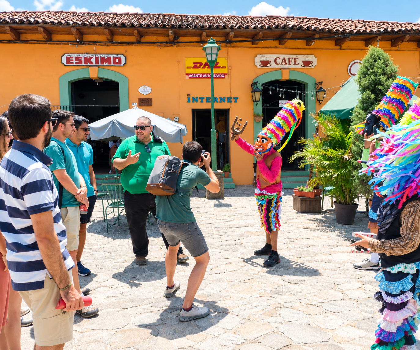 Viajeros observando una danza tradicional con trajes coloridos frente a un café de fachada colonial