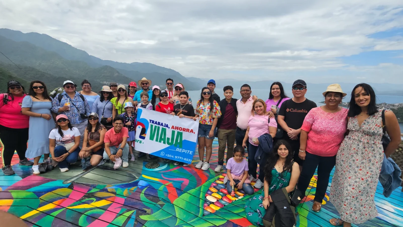 Grupo de viajeros de H Tours con su pancarta en un mirador al aire libre